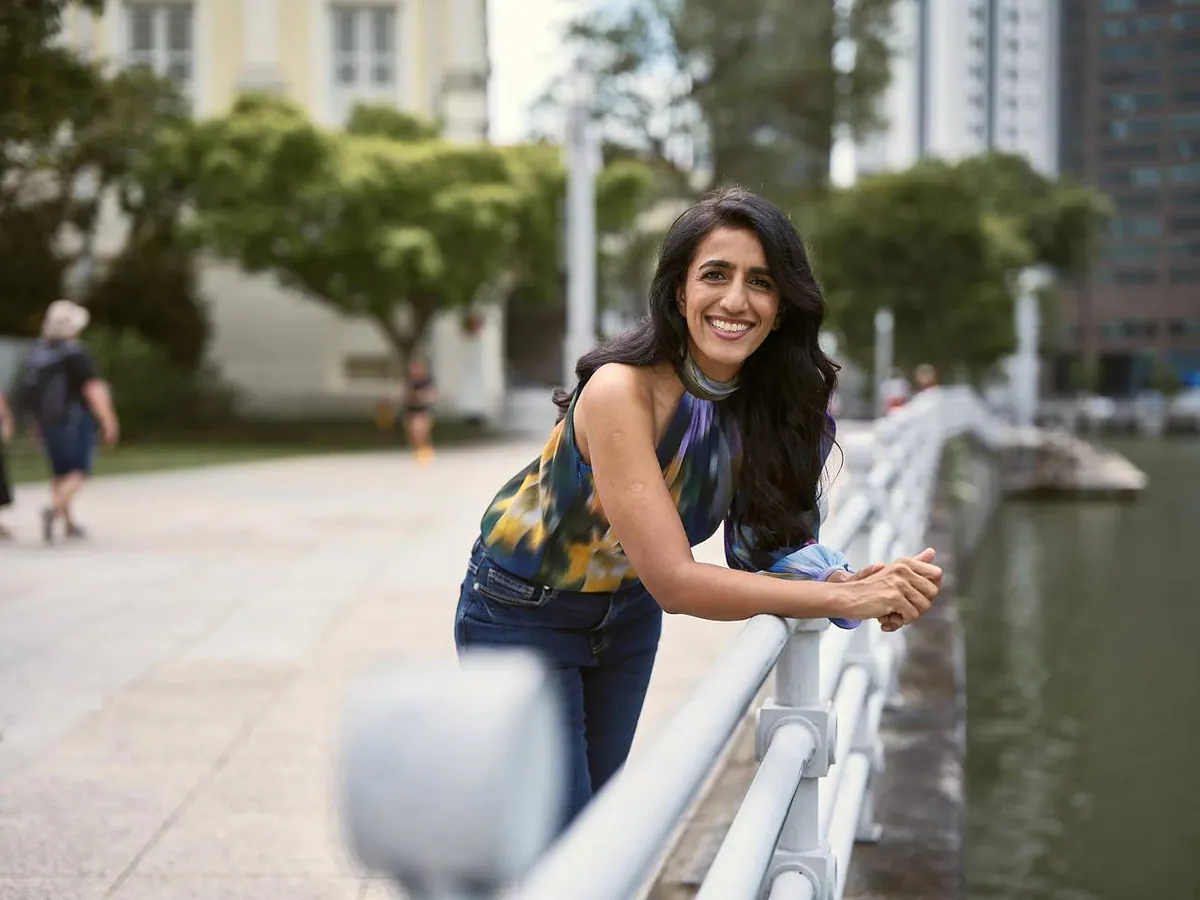 Dr. Ayesha Khanna, co-founder of Addo AI, smiling as she leans on a railing by the water